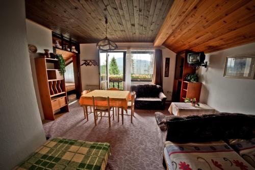 a living room with a table and a couch at Penzion Janouškovi in Harrachov