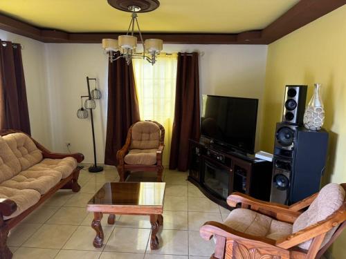 a living room filled with furniture and a flat screen tv at Aloft Alvarado in Siguatepeque
