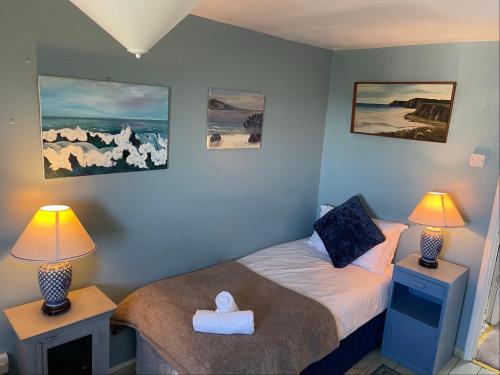 a small bedroom with a bed and two lamps at 11 Penygroes in Llantrisant