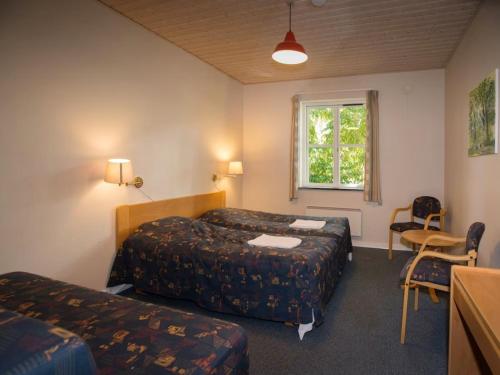 a hotel room with two beds and a table and a window at Femo Kro & Feriecenter by DanCenter in Nørreby