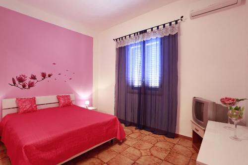 sypialnia z czerwonym łóżkiem i telewizorem w obiekcie Casa Pagani w mieście Nardò