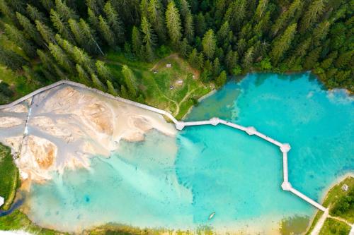 an aerial view of two blue ponds in a forest at Ecrin Blanc Resort Courchevel - Aquapark in Courchevel