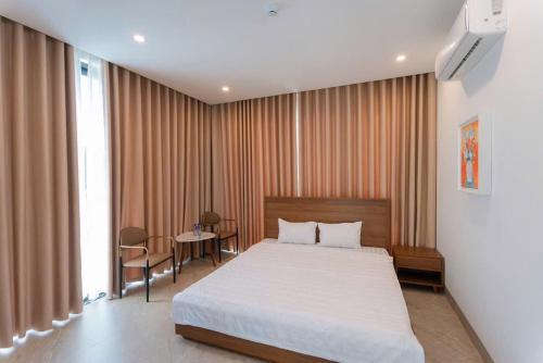 a bedroom with a large bed and a table at Villa Flamingo Hải Tiến in Thanh Hóa