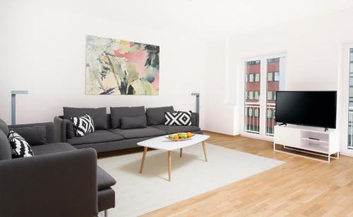a living room with a couch and a tv at Victoria Apartments in Düsseldorf