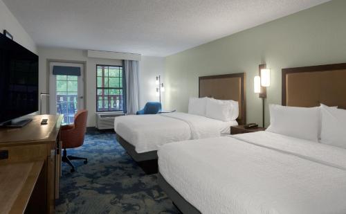 a hotel room with two beds and a flat screen tv at Hampton Inn Helen in Helen