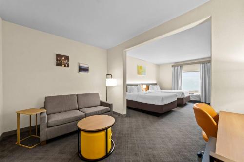 a hotel room with a bed and a couch at Comfort Suites San Antonio North - Stone Oak in San Antonio