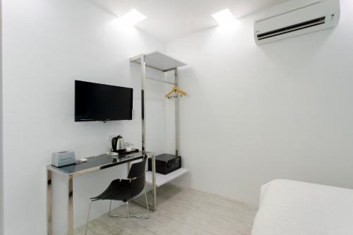a bedroom with a desk and a tv and a bed at Aloha Hotel SDN BHD in Pontian Kecil