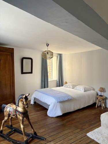 a bedroom with a bed and a statue of a dog at L'Escapade Maillotine in Joigny
