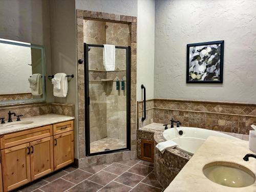 a bathroom with a shower and a tub and a sink at Hilton Grand Vacations Club Stonewater Cove Shell Knob in Shell Knob
