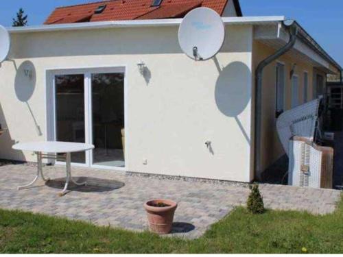 a white building with a table in front of it at Ferienhaus Ostsee Antje Bellmann in Kemnitz