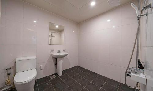 a white bathroom with a toilet and a sink at 충주 호텔 발리 in Chungju