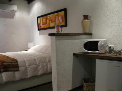 a bedroom with a bed and a microwave on a counter at Finca El Amparo in Los Reartes