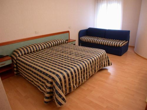 a bedroom with a bed and a blue couch at Hotel La Pergola in Rionero in Vulture