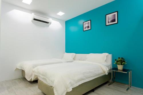 a bedroom with a blue wall and a bed at Aloha Hotel SDN BHD in Pontian Kecil