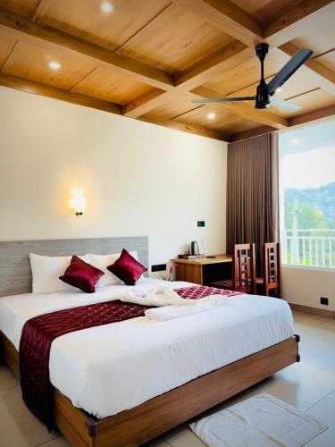 a bedroom with a large bed with red pillows at River Side Paradise By Greenleaves Munnar in Anachal