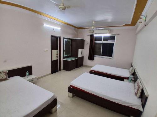a room with two beds and a television in it at The JANAKPURI in Ajmer