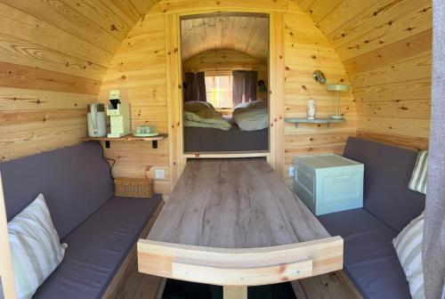 a wooden cabin with a wooden table in it at Obstgarten im Warnetal- Campingfass Kobel in Gielde