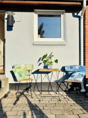 two chairs and a table in front of a building at PRIVATE B&B - EASY ACCESS - 24h SELF CHECK IN-OUT in Odense