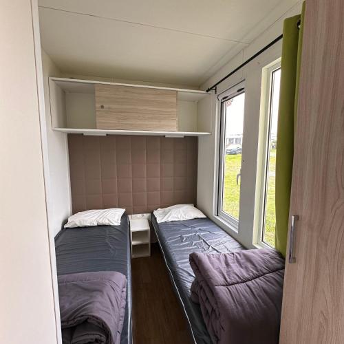 a small room with two beds and a window at Blueportel Prestige in Le Portel