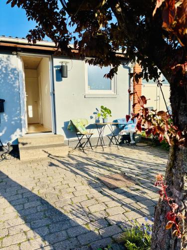 a patio with chairs and a table in front of a house at PRIVATE B&B - EASY ACCESS - 24h SELF CHECK IN-OUT in Odense