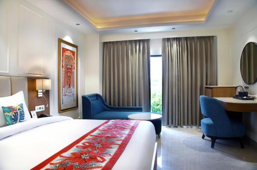 a hotel room with a bed and chairs and a desk at Wingston A TreeHouse Hotel, Mathura in Mathura