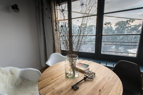 a wooden table with a vase on top of it at The Pines Boutique Villa in Braşov