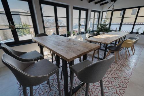 a group of tables and chairs in a room with windows at The Pines Boutique Villa in Braşov