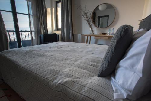a bedroom with a large bed and a mirror at The Pines Boutique Villa in Braşov