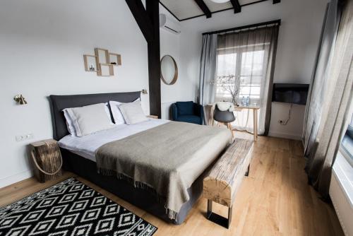 a bedroom with a bed and a table and a window at The Pines Boutique Villa in Braşov