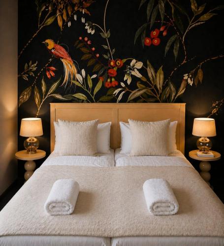 a bedroom with a large bed with two white towels on it at Apartamenty Staszica in Bielsko-Biała