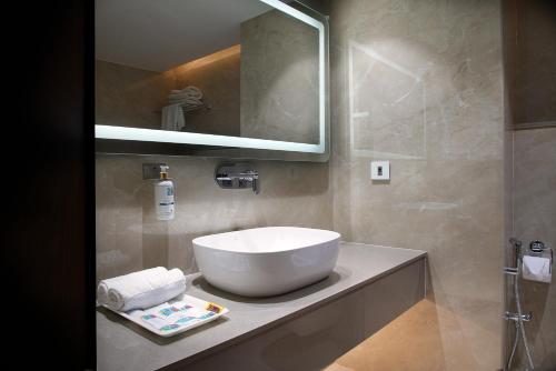 a bathroom with a white sink and a mirror at Wingston A TreeHouse Hotel, Mathura in Mathura