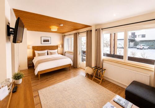 a bedroom with a bed and a large window at Chalet Bodenschatz in Vandans