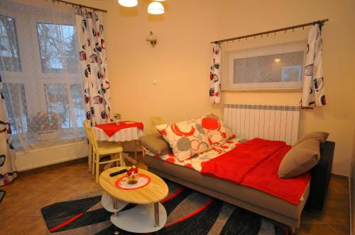 a small bedroom with a bed and a table at Apartament U Jacka in Rabka-Zdrój