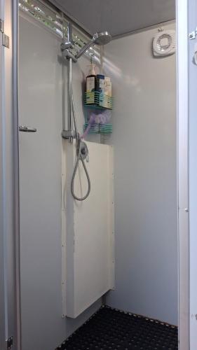 a shower in a bathroom with a white wall at Caravan Rustic Sunflower in Mount Crosby