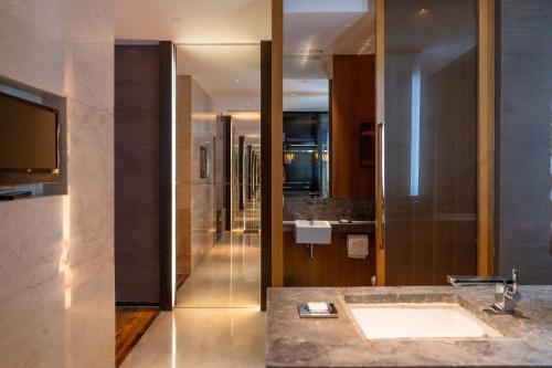 a bathroom with a sink and a large mirror at Grand Hyatt Guangzhou in Guangzhou