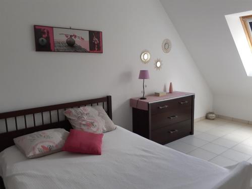 a bedroom with a bed and a dresser with a red pillow at Villa Le Clos de Mosny in Amboise