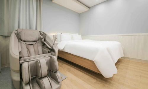 a hotel room with a bed and a suitcase at Hey, Jecheon Hotel in Chech'ŏn-yŏk