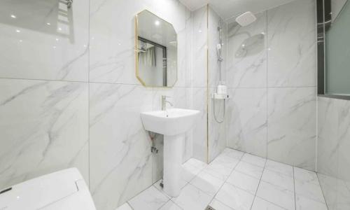 a white bathroom with a sink and a shower at Hey, Jecheon Hotel in Chech'ŏn-yŏk