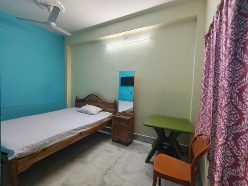 a room with two beds and a desk and a chair at Mayur Lodge And Restaurant in Khejuria Ghāt