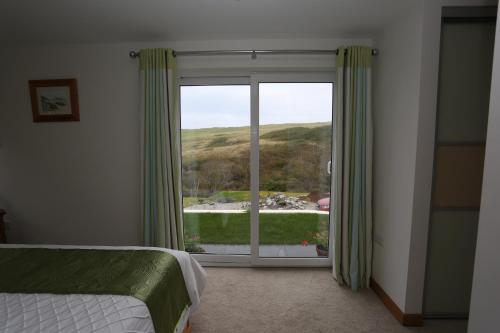 a bedroom with a large window with a view at Holywell Bay B & B in Newquay