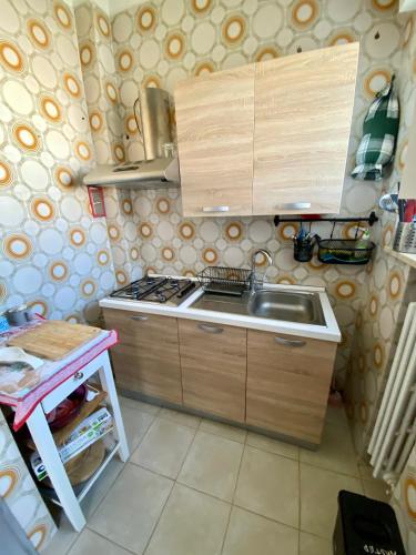 a small kitchen with a sink and a stove at Stanza matrimoniale bagno privato in Mola di Bari