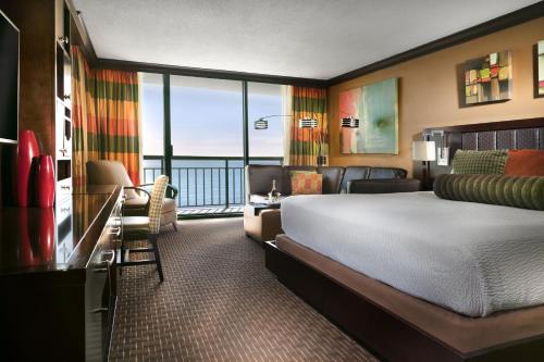 a hotel room with a bed and a balcony at The San Luis Resort Spa & Conference Center in Galveston
