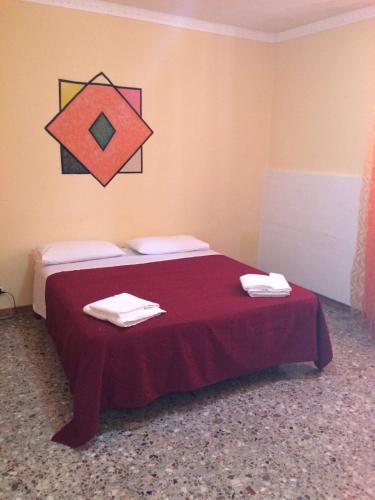 a bedroom with a bed with a red bedspread on it at Affittacamere di Fabio Principale in Talsano