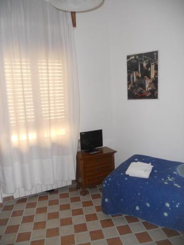 a bedroom with a bed and a desk and a window at Il Pozzo Della Citerna in Castelnuovo Berardenga