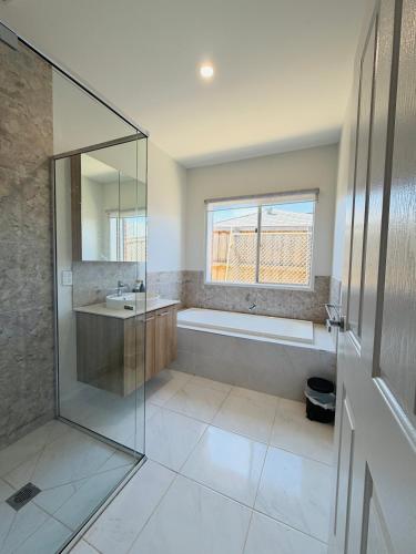 a bathroom with a shower and a sink and a tub at The Quiet Stay in Wyndham Vale
