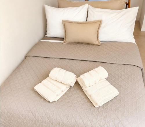 a bed with two white towels on it at Thaleia apartment in Igoumenitsa