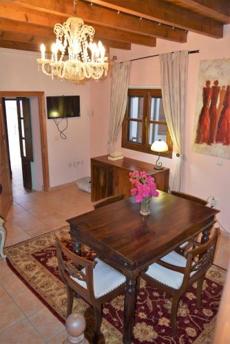 a dining room with a table and chairs and a chandelier at Petrino in Rhodes Town