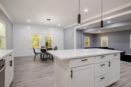 a kitchen with white cabinets and a table with chairs at Large 3 bed 2 bath home in Mobile