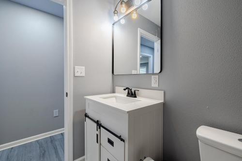 a white bathroom with a sink and a mirror at Large 3 bed 2 bath home in Mobile
