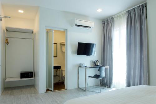 a bedroom with a bed and a window and a desk at Aloha Hotel SDN BHD in Pontian Kecil